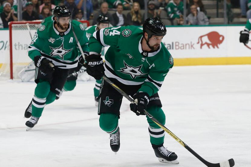 Dallas Stars wing Jamie Benn skates the puck upice as center Tyler Seguin trails against the...