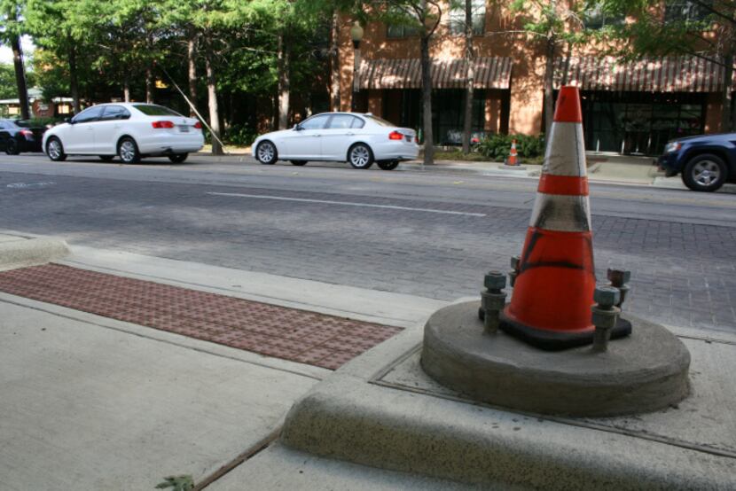 A traffic cone sits over the base where the pole for the future High-intensity Activated...
