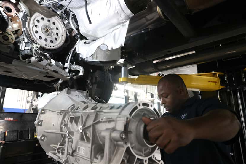 Emmanuel Walker raises a Ford F-150 transmission into a truck at Five Star Ford of Dallas.