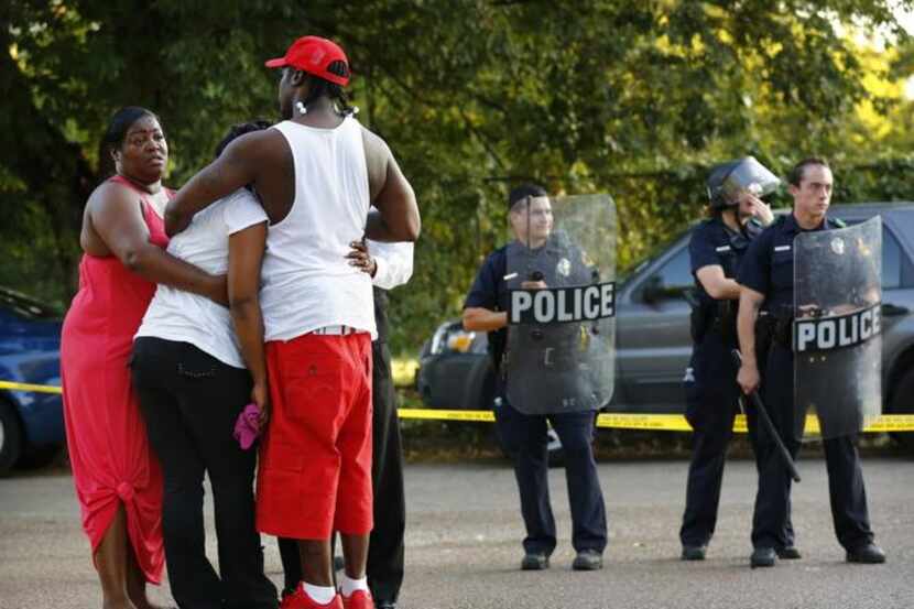
Dixon Circle residents prayed near a police line on July 24, 2012, after a shooting by an...