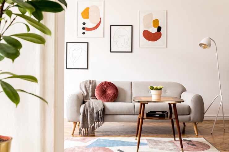 Modern apartment interior with artwork on the walls, a white standing light fixture, a...