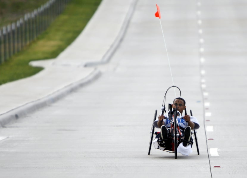 Addis Gonte, 20, hand cycles in his neighborhood in Sachse on July 17, 2013. At age 16,...