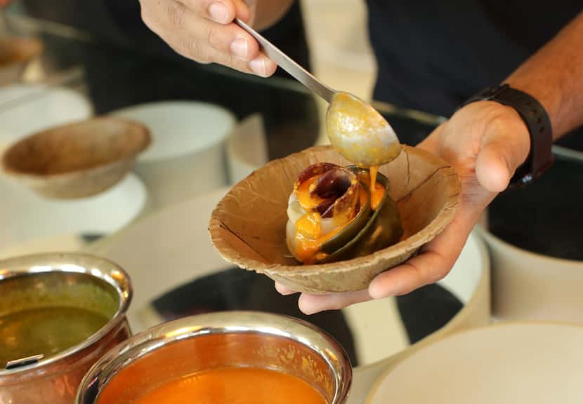 Leezen Amatya with Momo Shack Himalayan Dumplings serves a dumpling.