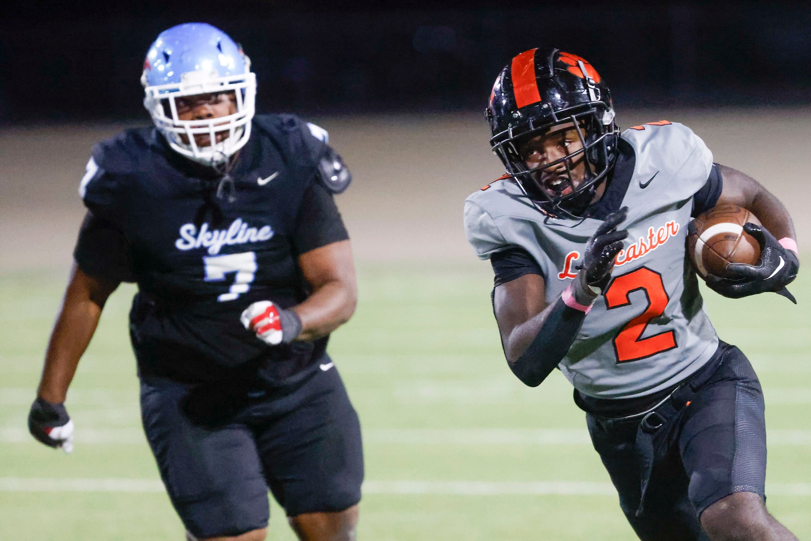 Lancaster High’s Izayah Lee (right) runs for a yardage during the second half of a football...