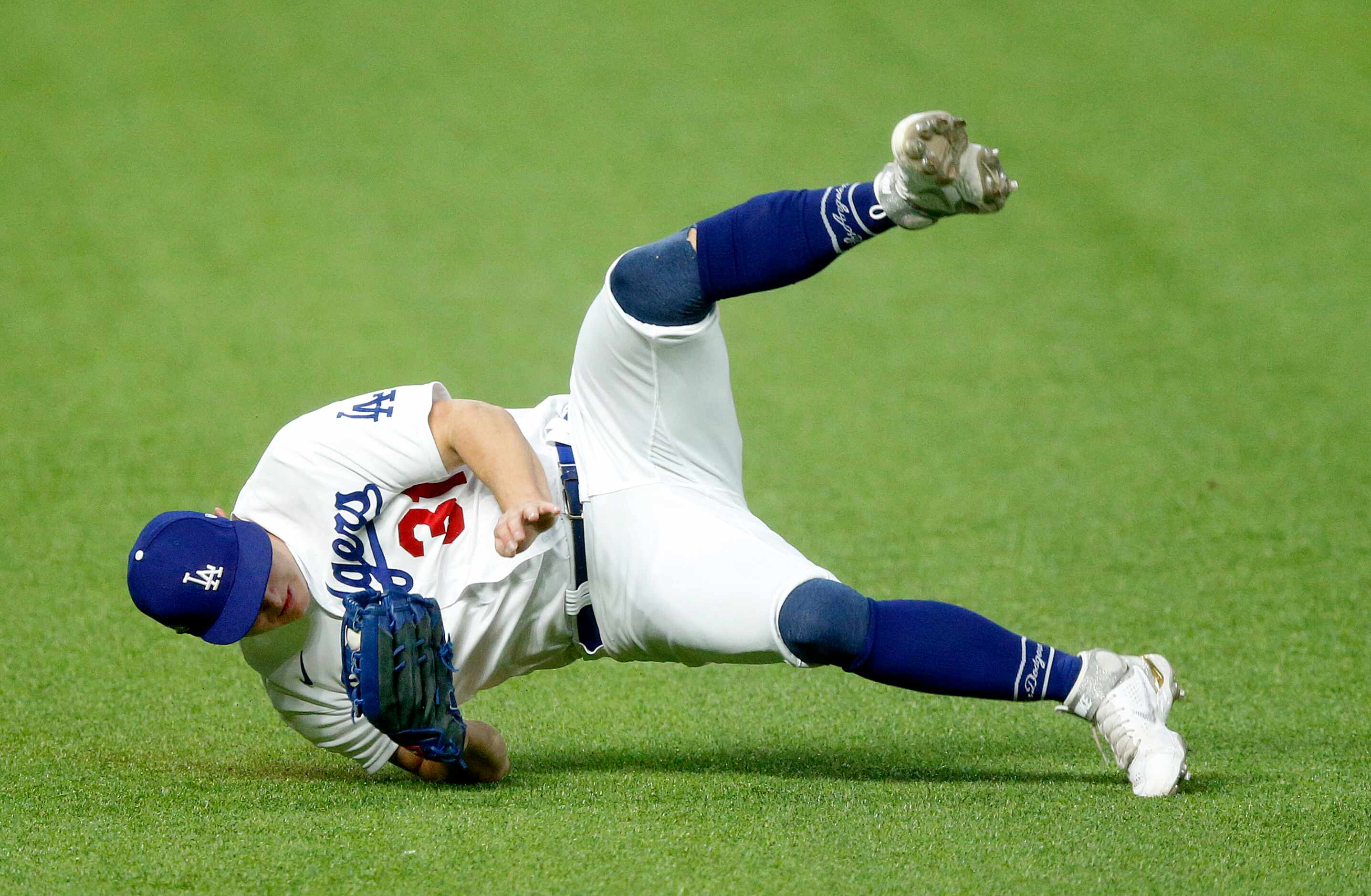 Los Angeles Dodgers left fielder Joc Pederson (31) rolls after making a sliding catch of...