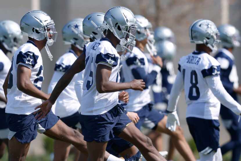 Dallas Cowboys rookie wide receiver T.J. Vasher (15) and his teammates warm up during rookie...