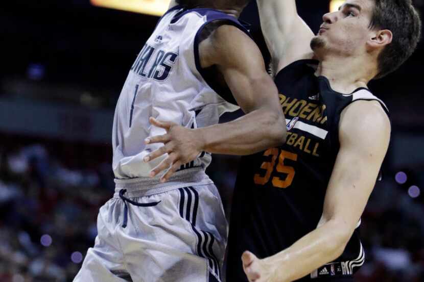 Dallas Mavericks' Dennis Smith Jr., left, shoots around Phoenix Suns' Dragan Bender during...
