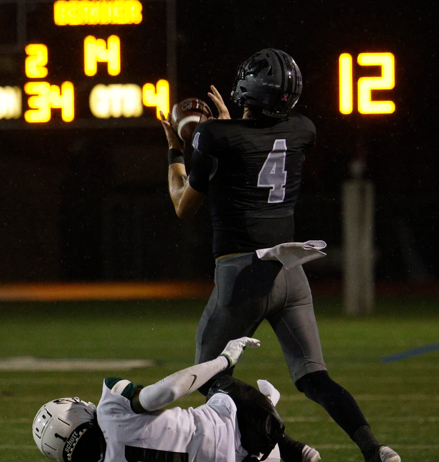 Martin's Logan Baresh (4) catches a pass under pressure from Berkner's Kobi Foreman (1)...