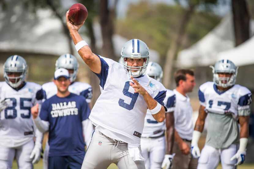 Dallas Cowboys quarterback Tony Romo throws a pass during afternoon practice at training...