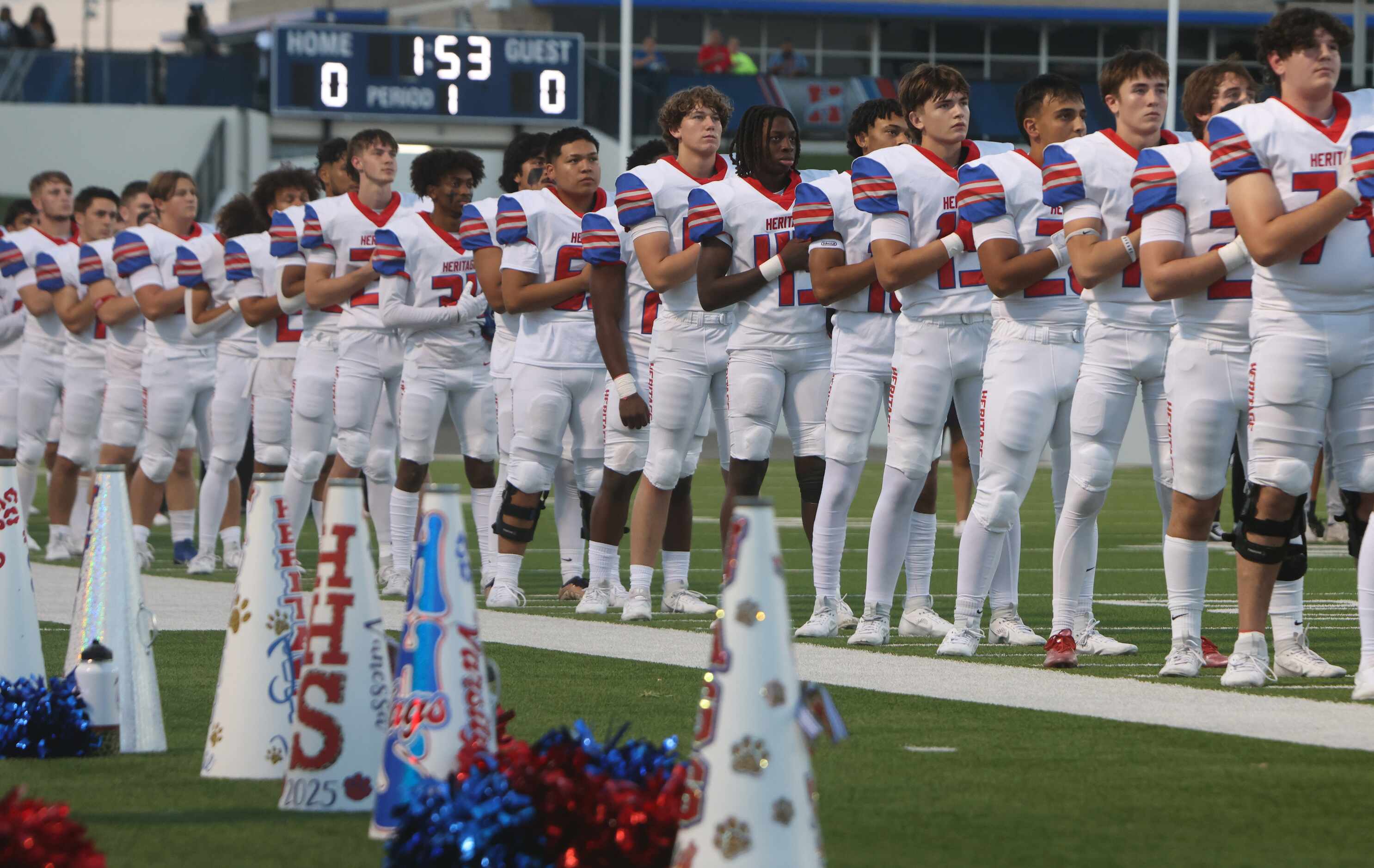 Midlothian Heritage players pause for the playing of the national anthem prior to the...