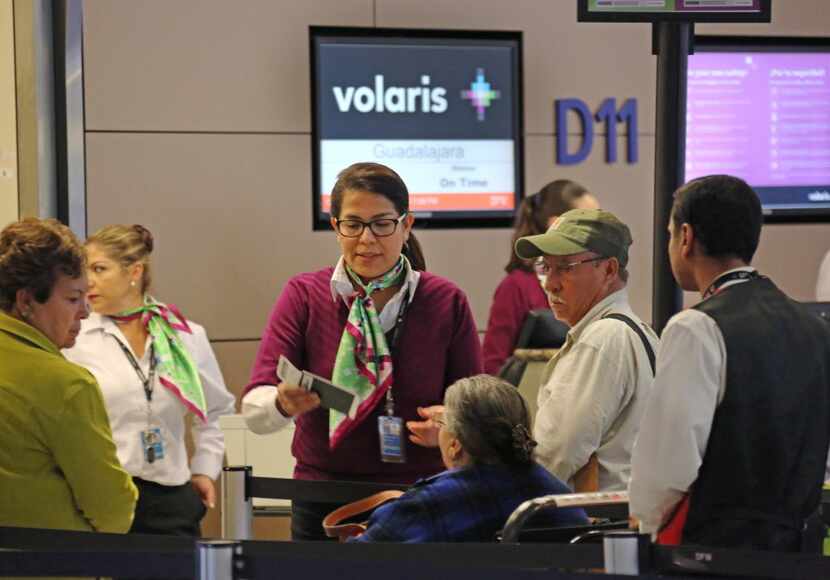 Agents help passengers at the Volaris gate in Terminal D at DFW Airport, photographed on...