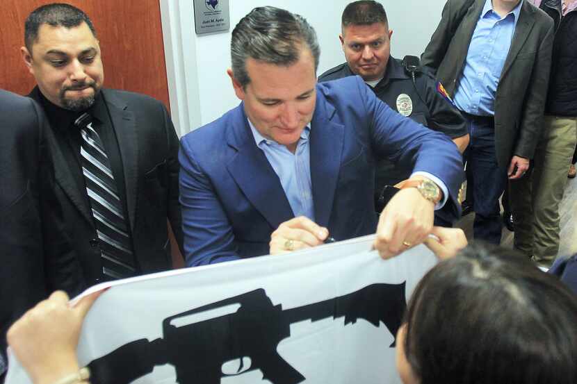 U.S. Senator Ted Cruz, R-Texas, signs a pro gun flag for supporters as he campaigns for...