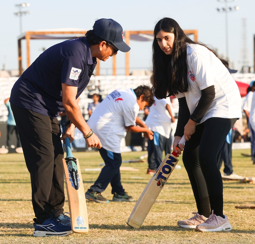 Cricket legend Sachin Tendulkar, helps young crickets with batting tips during a training...