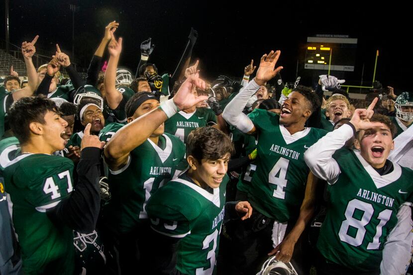Arlington High School players celebrate after winning the high school football game between...