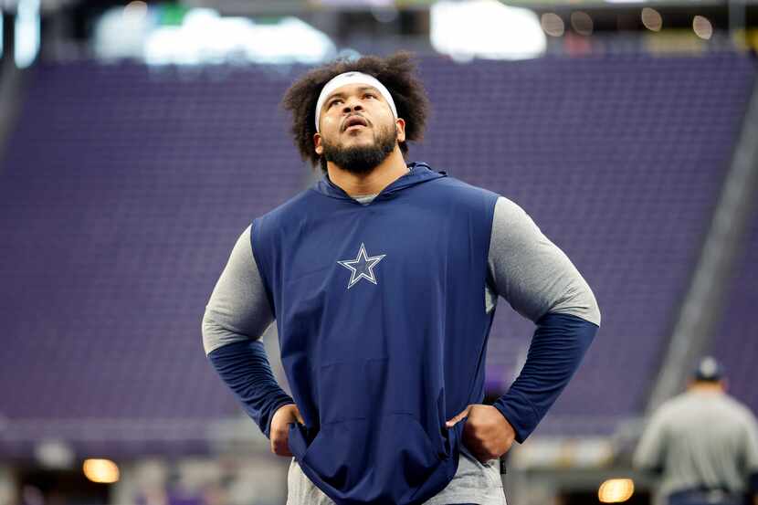 Dallas Cowboys offensive tackle La'el Collins takes a breather as he stretches and warms up...