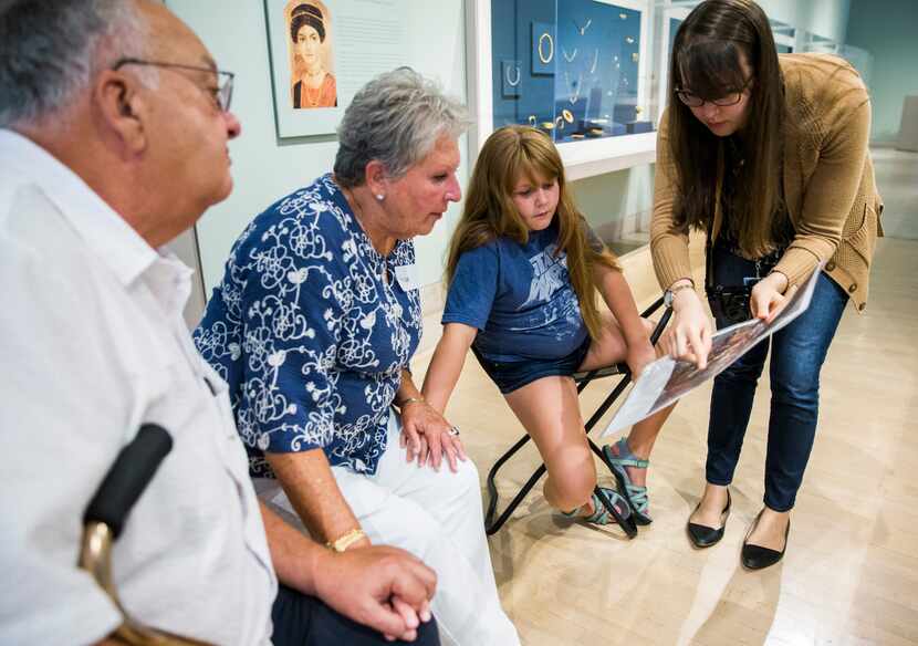 Alan and Hope Levine and their granddaughter Gretchen Jones, 9, looks at a photo of artwork...