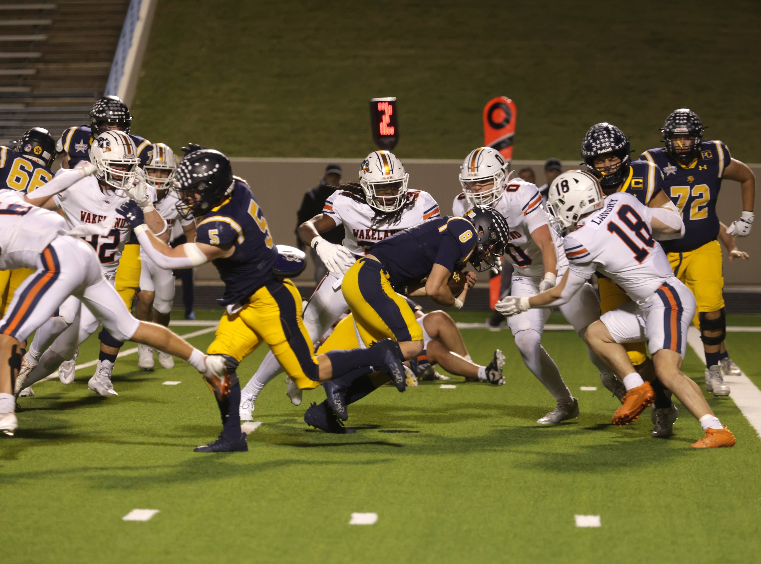 Highland Park quarterback Buck Randall runs into the Frisco Wakeland defense in a high...