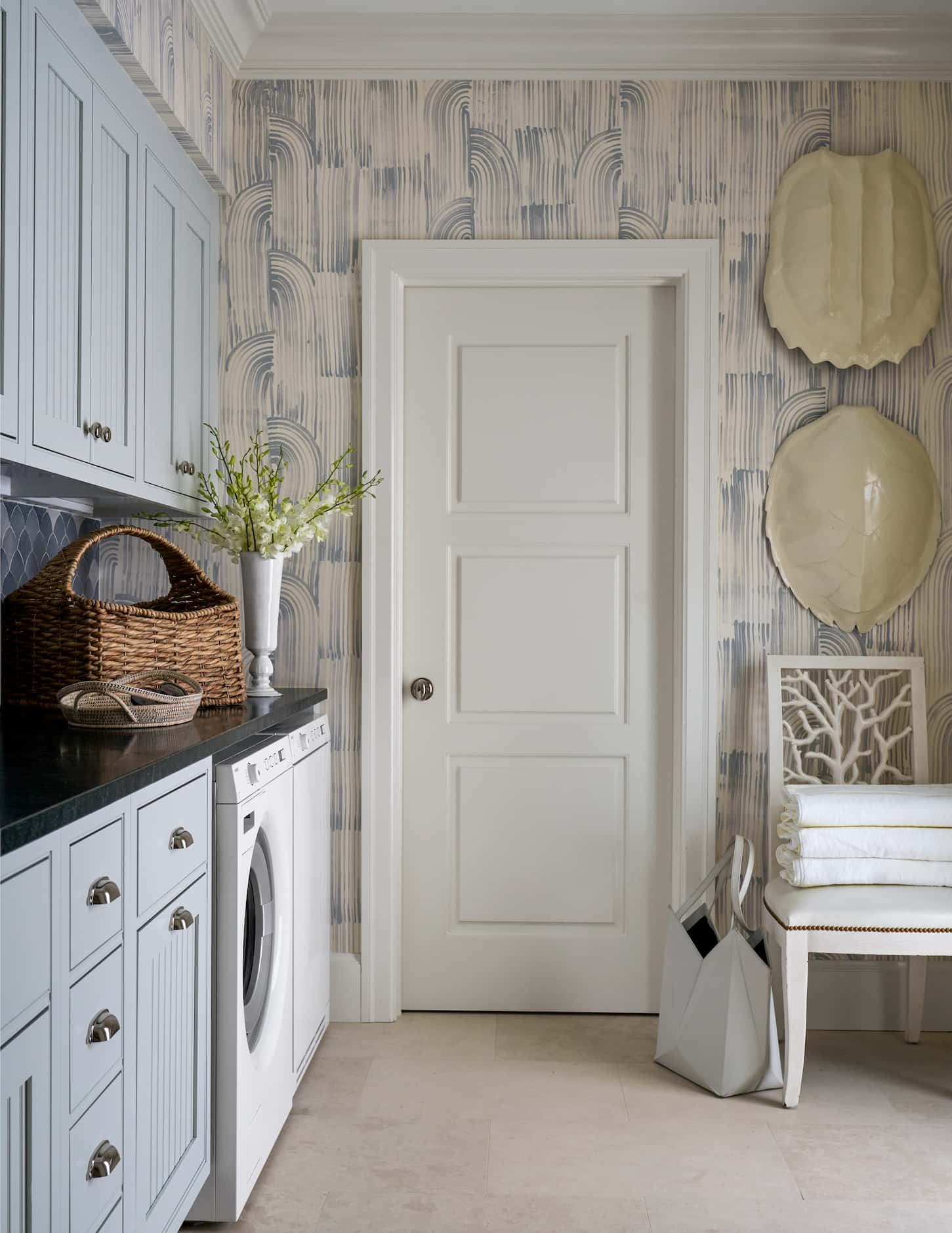 Laundry room with blue cabinetry and blue and white wallpaper