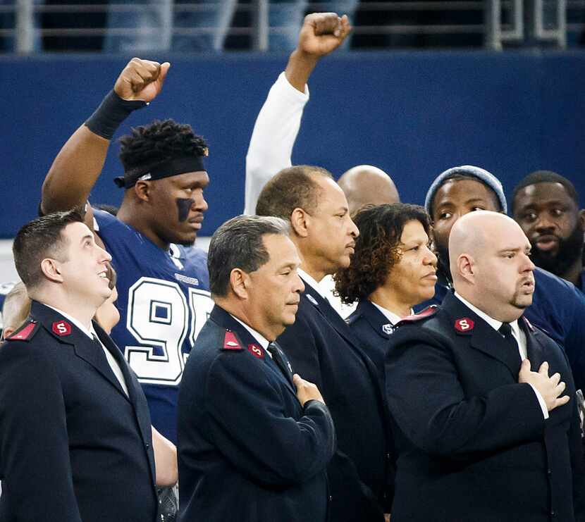 Dallas Cowboys defensive tackle David Irving raises a fist at the end the national anthem...