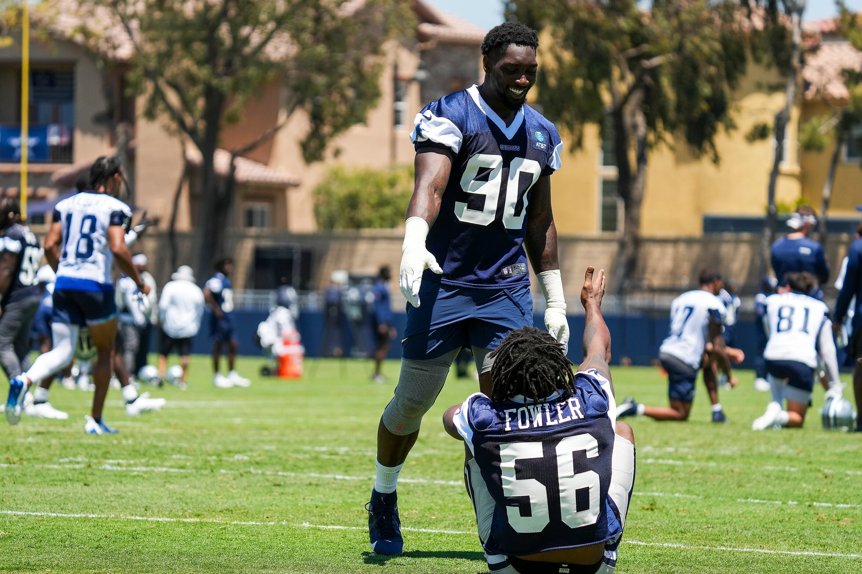 Dallas Cowboys defensive end Dante Fowler Jr. (56) gets a hand from defensive end Demarcus...