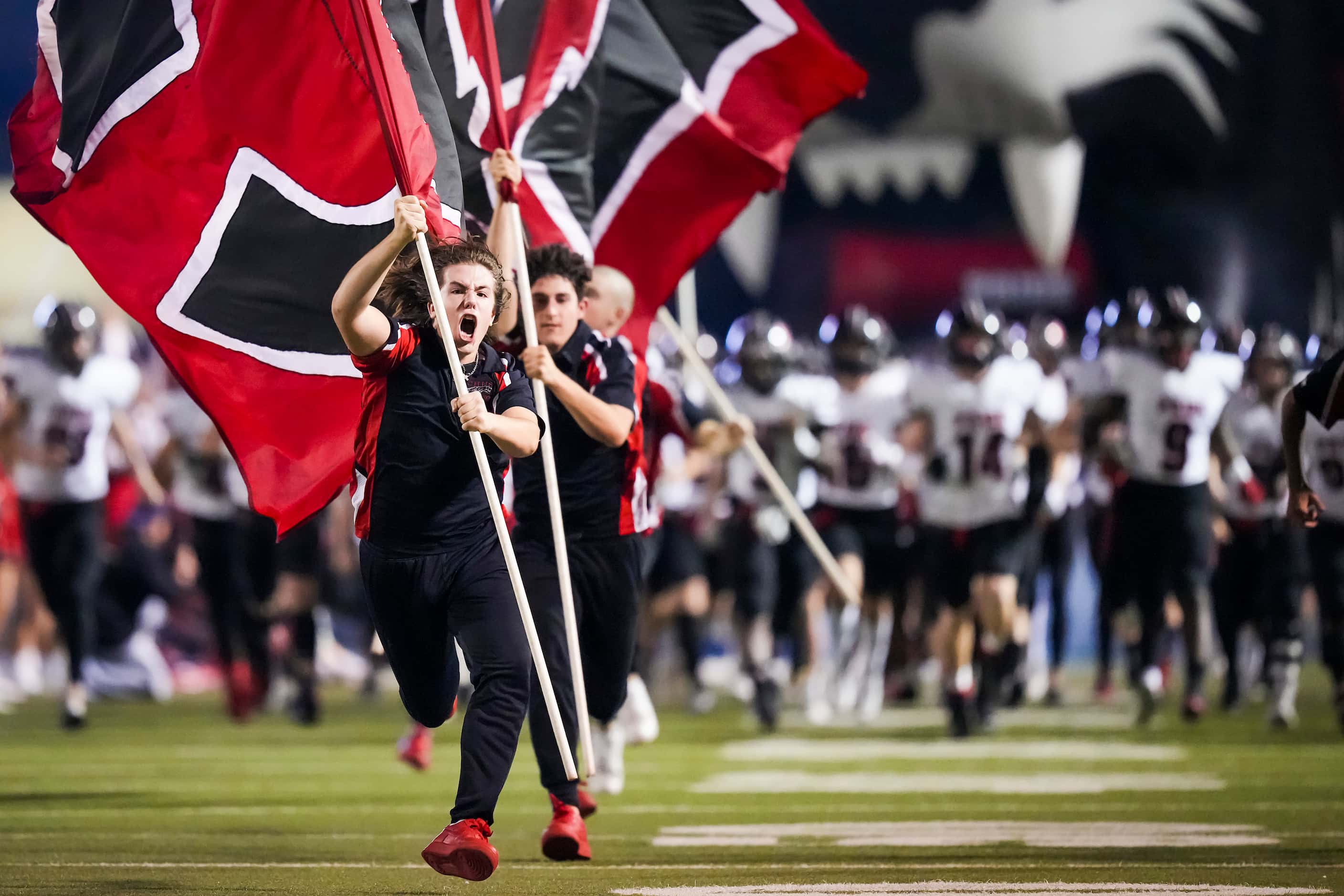 Colleyville Heritage flag runners lead their team as they take the field for the first half...