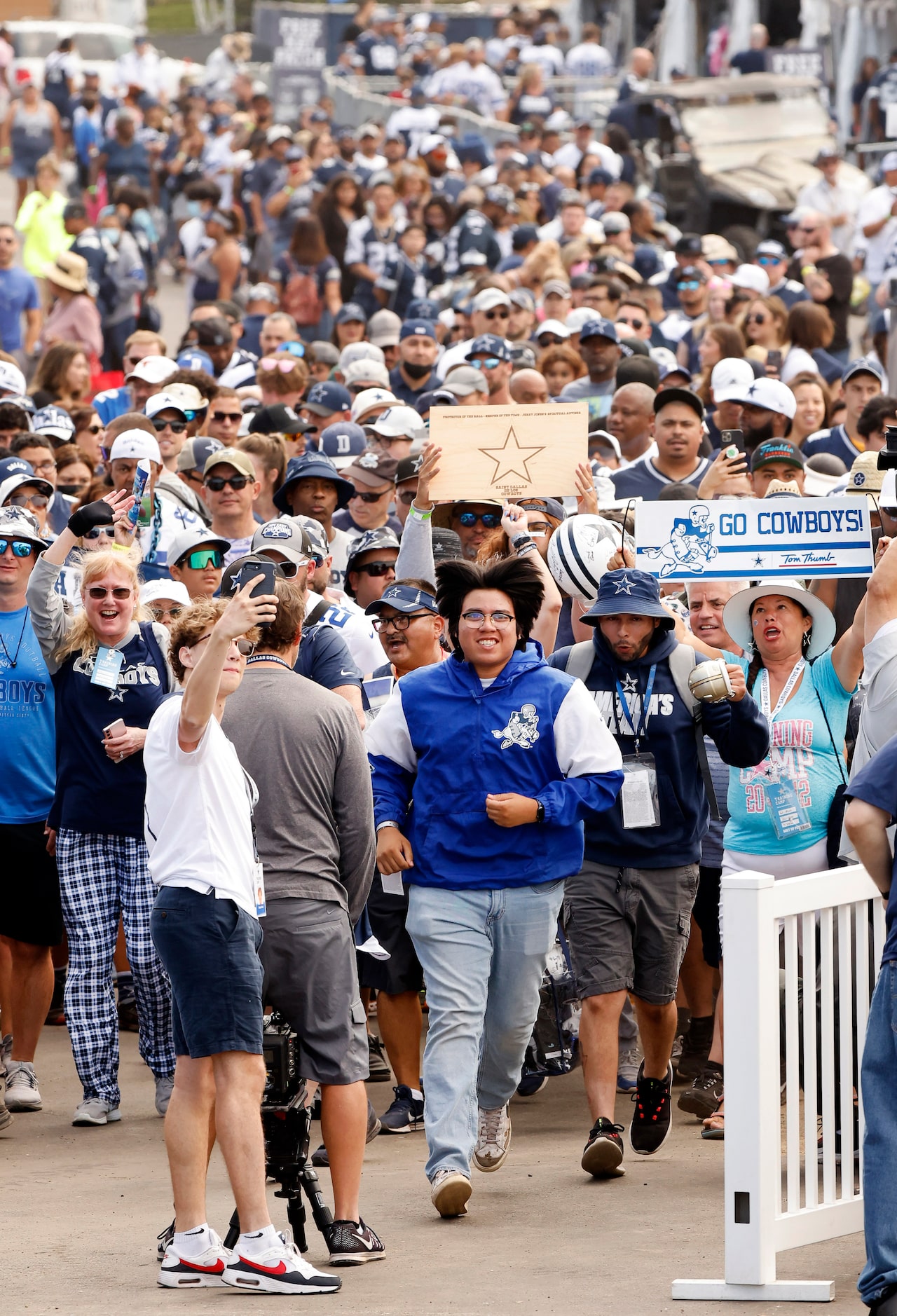 The first Dallas Cowboys fans rush to the playing fields after the gates were opened for...