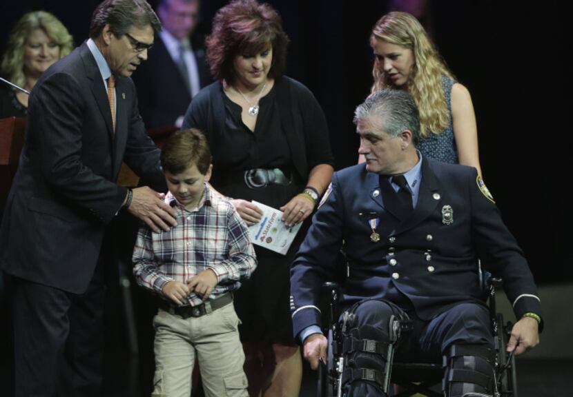 Gov. Rick Perry greets the family of firefighter Robert Yarbrough, who was injured in a...