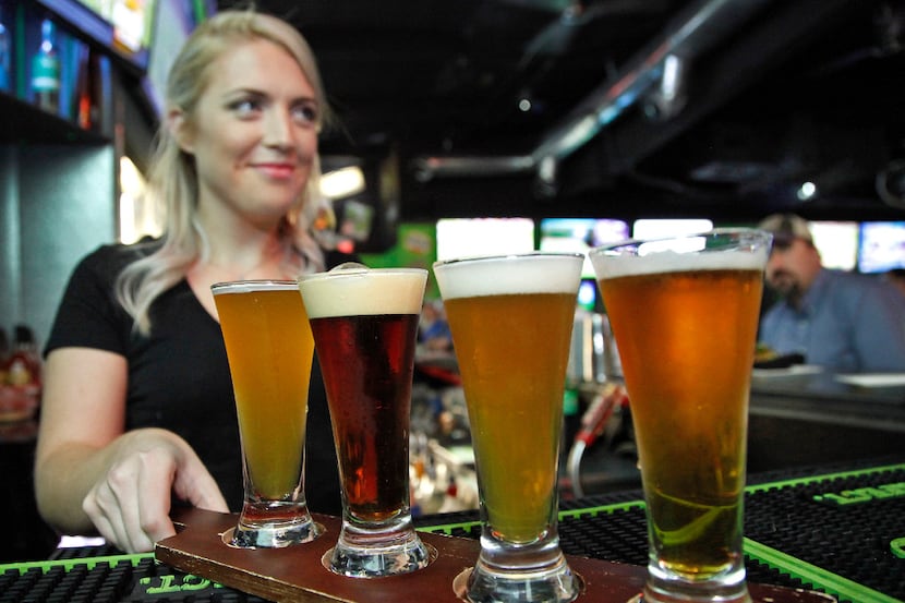 A waitress serves up a beer flight at the Drunken Donkey in Lewisville.