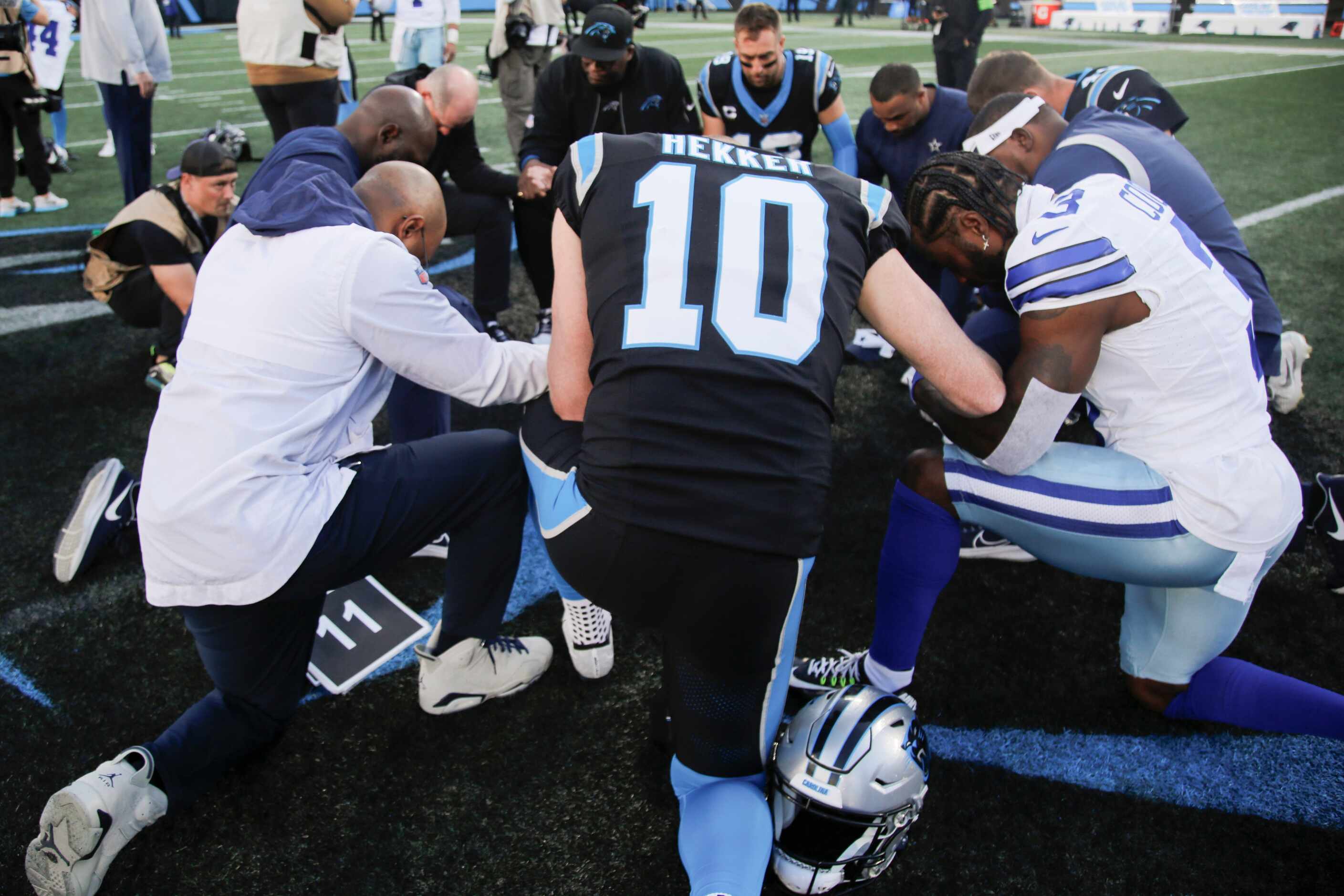 Dallas Cowboys and Carolina Panthers gather in prayer at the end of a NFL game at Bank of...