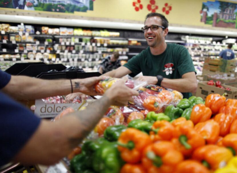 Jason Brick (right) and Jay Tome work on a produce display at Trader Joe's in Plano on...
