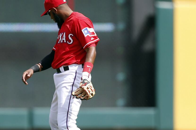 Texas Rangers shortstop Elvis Andrus (1) cant keep a grip on the ball hit by Philadelphia...