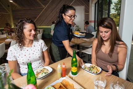 Taco Heads server Guadalupe Barrera, center, serves Allison Ondocsin, left, and Jessica...