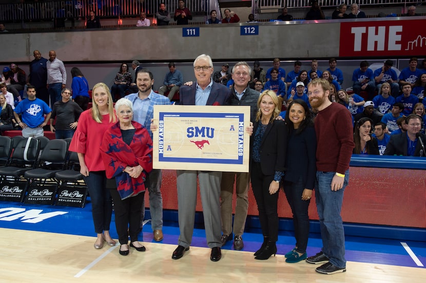 David Miller (center) held a piece of flooring as he stood with his family on Dec. 5, 2018,...