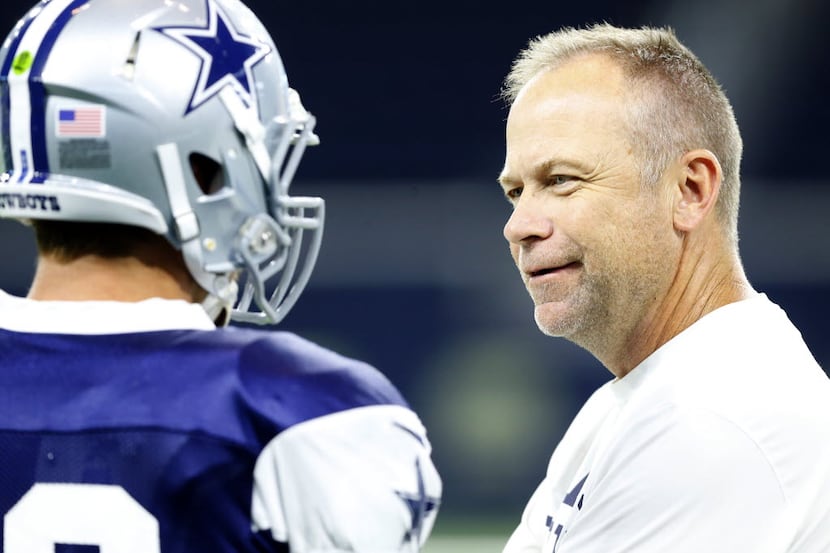 Dallas Cowboys offensive coordinator Scott Linehan (right) visits with outside linebacker...