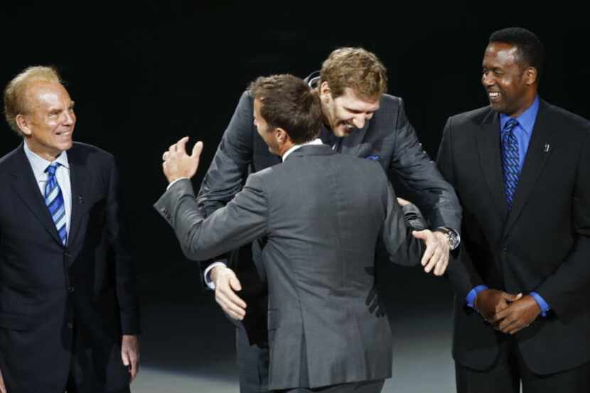Mike Modano hugs Dirk Nowitzki during his  jersey retirement ceremony as Troy Aikman, Roger...