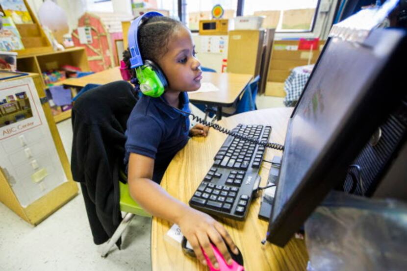 
Pre-kindergarten student Kennedy Wade, 4, works at a computer in her classroom as part of...