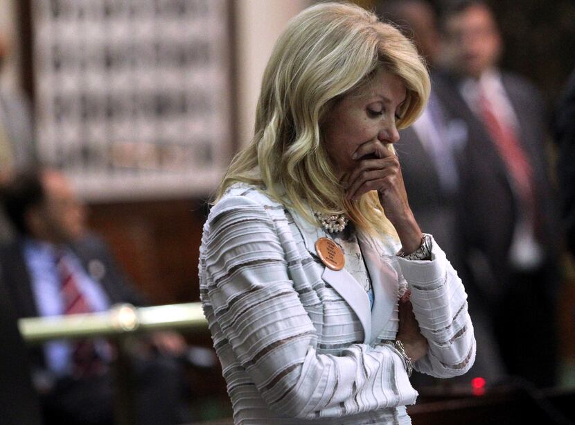 State Senator Wendy Davis reacts after a third point of order halts her filibuster during...
