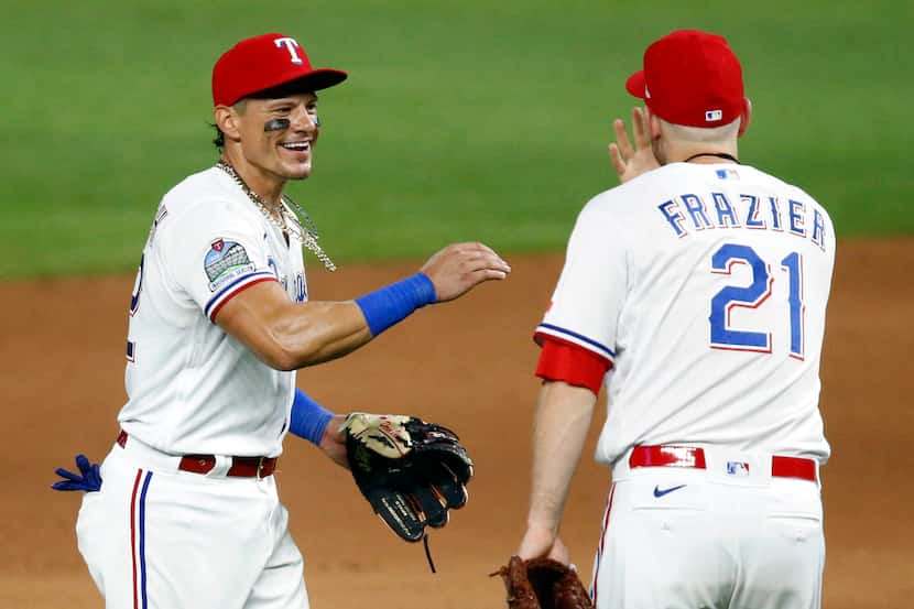 Rangers second baseman Derek Dietrich (32) is congratulated on his good game by teammate...