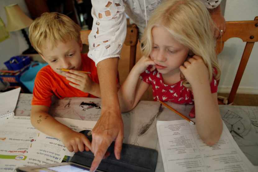 Luka Perge and Hadley O'Donnell-Downer, both 6, work with Angela Perge in the home-school...