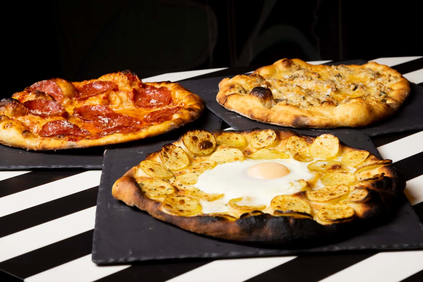 (From left) The pepperoni pizza, potato truffle and egg pizza, and white clam pizza...