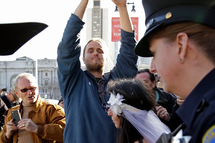 David DePape, center, records Gypsy Taub being led away by police after her nude wedding...