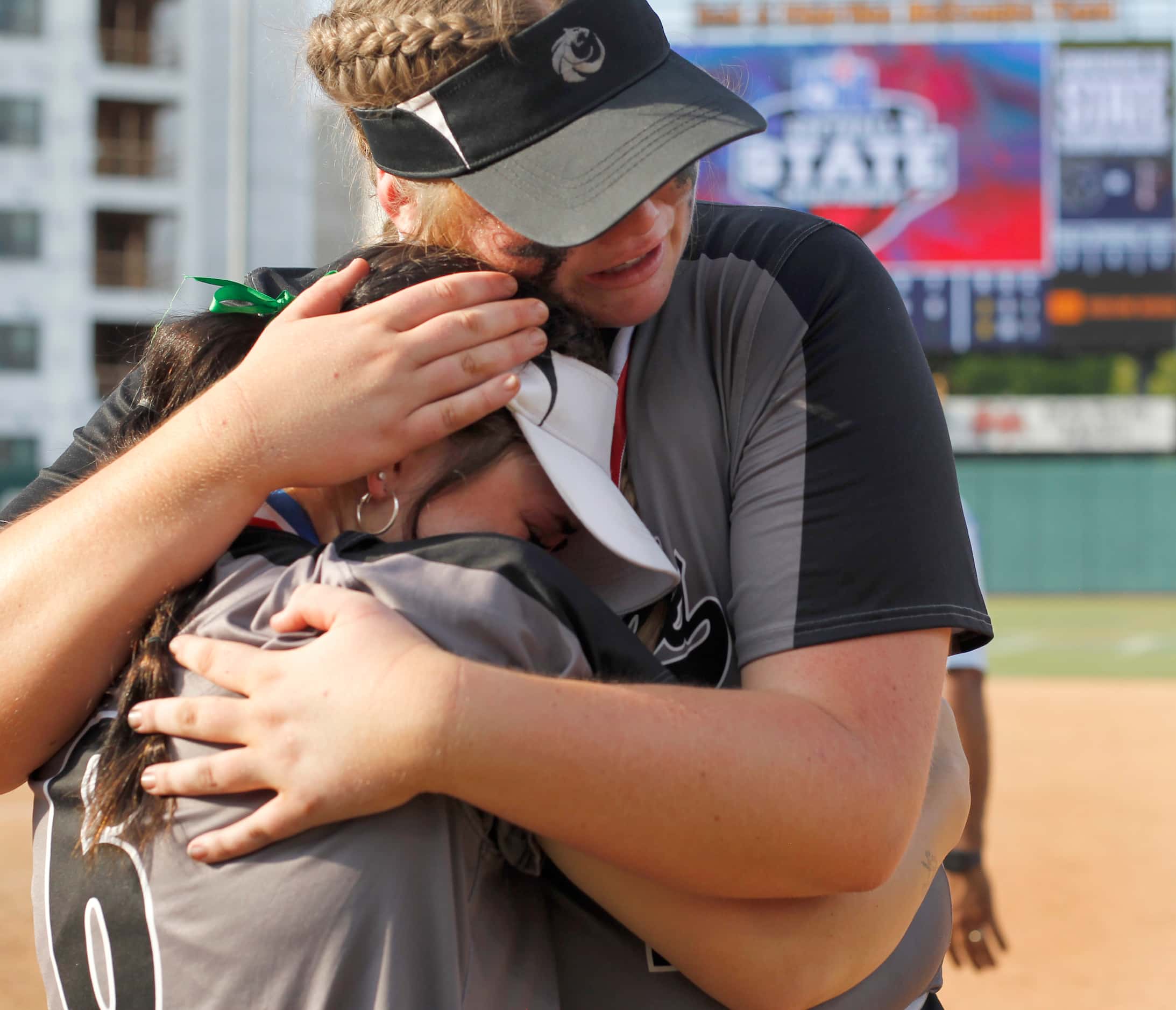 Denton Guyer pitcher Finley Montgomery (20) shares a consoling hug with teammate Kaylynn...