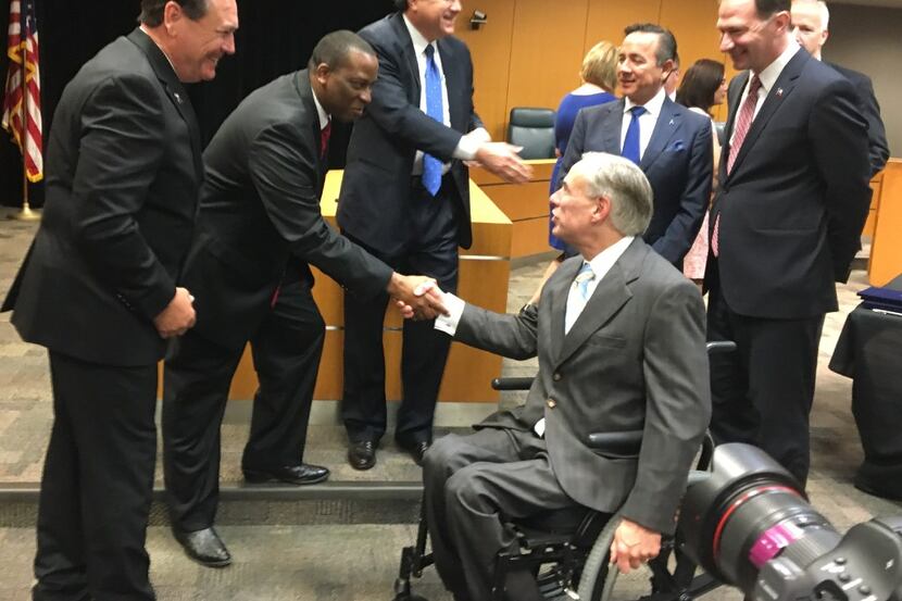 Gov. Greg Abbot shook hands with Charles Smith,  executive commissioner of health and human...