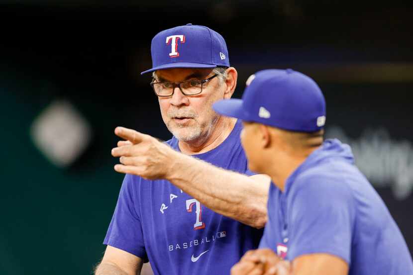 Texas Rangers manager Bruce Bochy talks in the dugout during a practice before Game 3 of an...