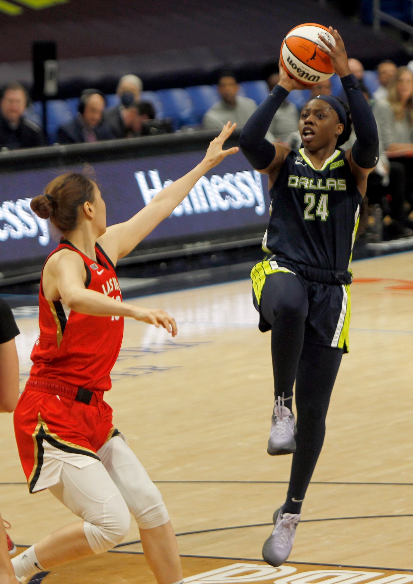 Dallas Wings guard Arike Ogunbowale (24) puts up a jump shot over the defense of Las Vegas...