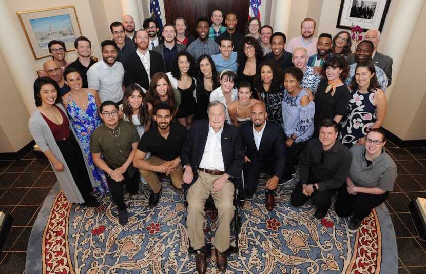 Cast members from Hamilton pose for a photo with former President George H.W. Bush after...