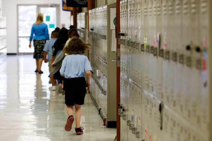 
First-grade students move down the hallway of a temporary modular building at Edna Rowe...