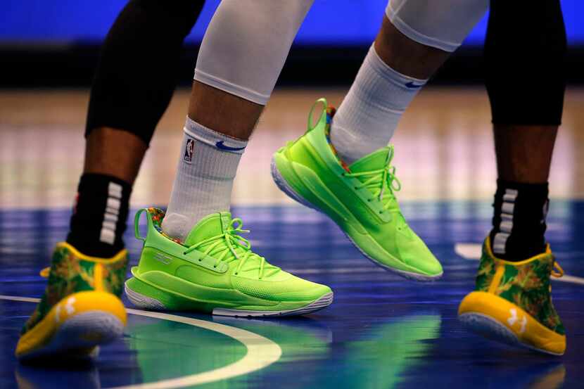 Dallas Mavericks forward Luka Doncic (center) wore florescent green shoes as San Antonio...