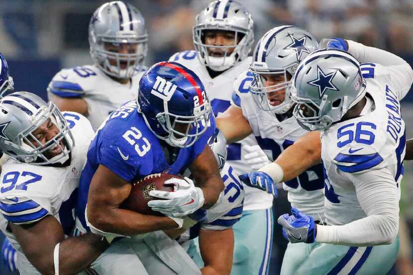 A host of Dallas defenders stops New York Giants running back Rashad Jennings (23) in the...