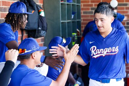 Texas Rangers youth’s Emiliano Maldonado (right) gets congratulated by his teammates after a...